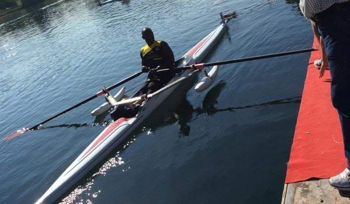 An athlete rows a single scull across the water, seen from above.