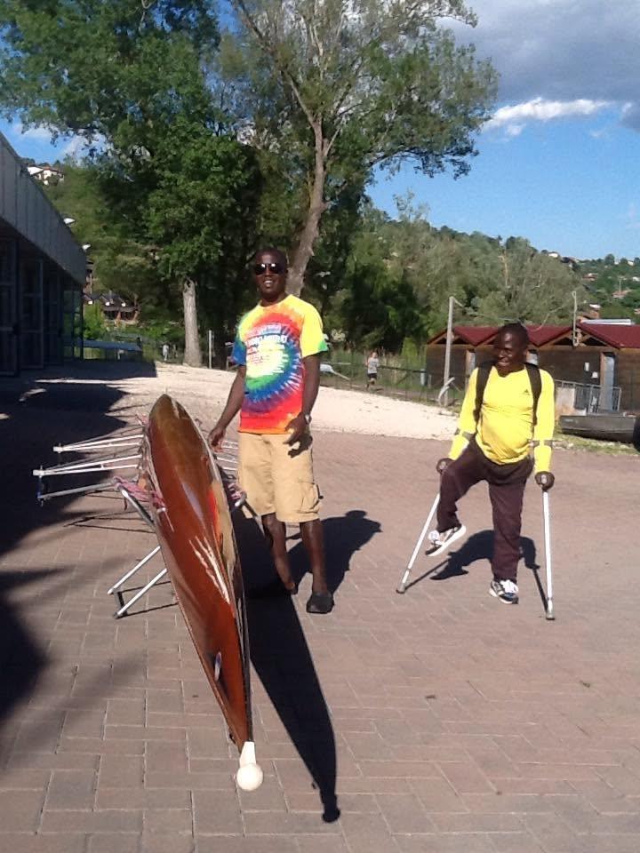 Participants stand with adaptive rowing equipment in a park.