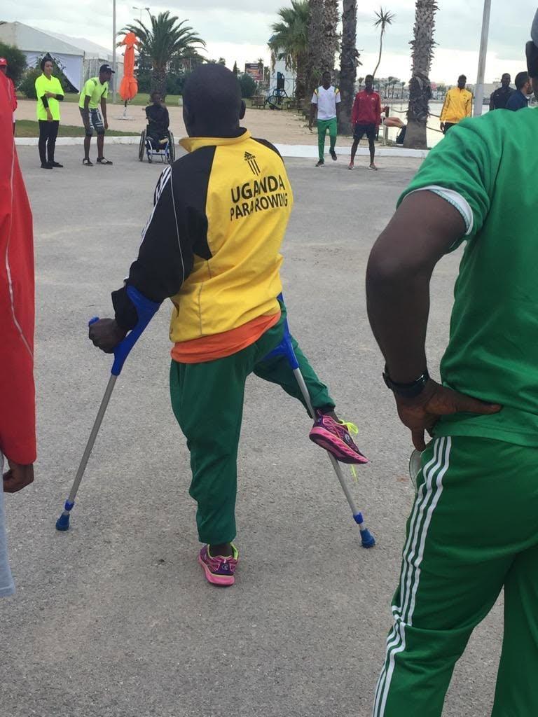 An athlete stands outdoors using crutches.