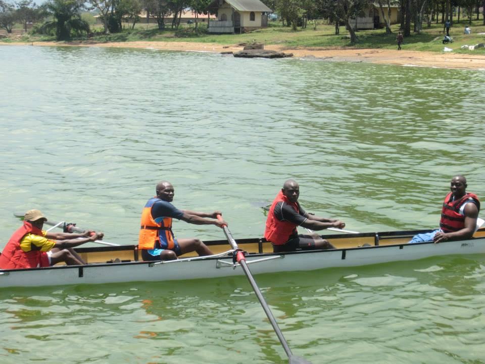 A crew of Para rowing athletes and a coxswain rowing together on the water.