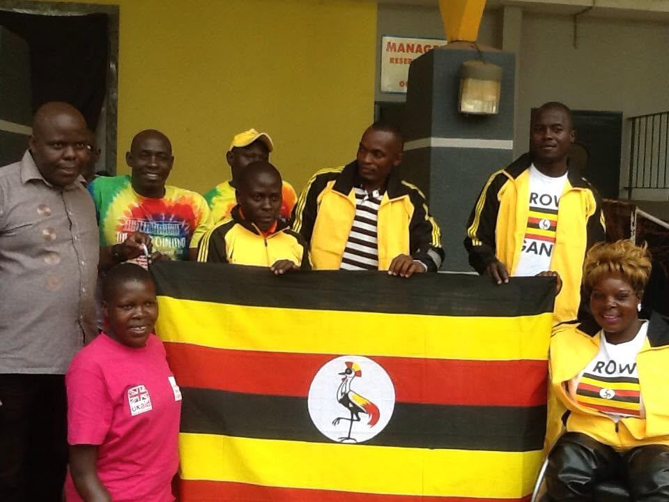 Federation members gather indoors with the Uganda flag.